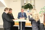 Minister Gorazd Žmavc schreibt einen Gruß ins Gästebuch der Landesbibliothek