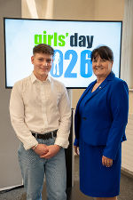 Zwei Personen stehen lächelnd vor einem Bildschirm mit dem Aufdruck "Girls' Day 2026".