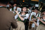 Bildbeschreibung: Ensemble in Tracht mit verschiedenen Instrumenten, darunter Flöte und Saxophon.