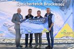Bildbeschreibung: Vier Personen halten ein Schild mit der Aufschrift „Wasser marsch“ vor einer Fotowand zum Speicherteich Bruckmoos.