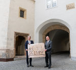 Landeshauptmann Christopher Drexler (l.) und Historiker Konstantin Moritz Langmaier (r.) vor der Doppelwendeltreppe und dem mittelalterlichen „A.E.I.O.U.“-Schriftzug (im Hintergrund rechts oben) im Hof der Grazer Burg.