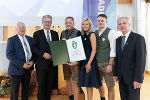 Bgm. Gerhard Konrad (l.) und LH Christopher Drexler (2.v.l.) bei der Überreichung des Landeswappens an GF Klaus Zidek (3.v.l.) und seine Familie. © Foto: derFlor; bei Quellenangabe honorarfrei Bgm. Gerhard Konrad (l.) und LH Christopher Drexler (2.v.l.) bei der Überreichung des Landeswappens an GF Klaus Zidek (3.v.l.) und seine Familie.