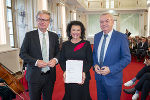 LH Christopher Drexler (l.) und LH-Stv. Anton Lang (r.) überreichten die Auszeichnung der Republik Österreich (Berufstitel Professorin) an Anita Frauwallner